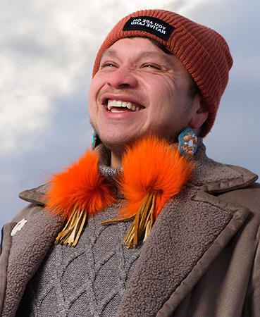 Abraham Francis wearing an orange hat and smiling